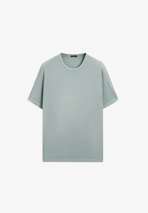 Lichtblauwe katoenen T-shirt met korte mouwen, een ronde hals en een relaxte pasvorm. Soepele textuur met een eenvoudig, strak ontwerp.