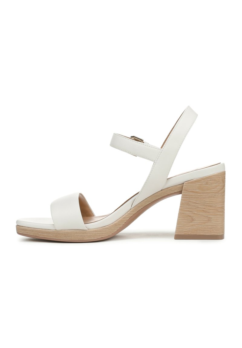 Sandali con tacco in pelle bianca, dotati di un tacco a blocco in legno, punta aperta e due cinturini regolabili alla caviglia. Texture liscia con design minimalista.