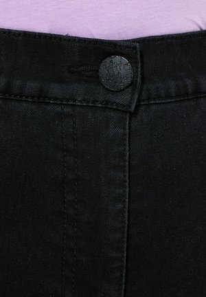 Czarne dżinsy z zapięciem na guzik i subtelnymi detalami w szwach. Teksturowana tkanina, ukazująca zbliżenie na talię i guzik.