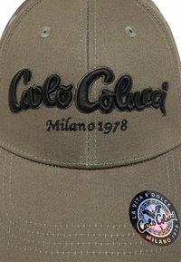 Khaki-Baseballmütze mit schwarzem gesticktem Logo "Carlo Colucci Milano 1978" und einem kreisförmigen holografischen Aufkleber an der Seite.