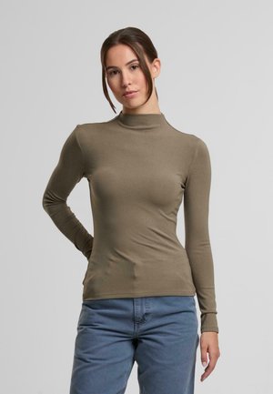 Oliven grøn langærmet turtleneck top, tætsiddende design, blødt materiale, sømløs finish, parret med lyseblå jeans.