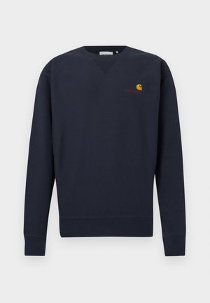 Granatowa bluza z dekoltem w szpic, ściągaczami przy rękawach i u dołu, z małym logo Carhartt w kolorach pomarańczowym i żółtym, wyhaftowanym na piersi.