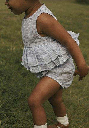 Lyseblå gingham to-dels outfit med lagdelt, flæset top og shorts. Bomuldsstof, blød tekstur og elastisk talje.
