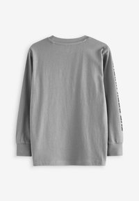 Langärmliges graues T-Shirt aus weicher Baumwolle, mit einem runden Ausschnitt und bedrucktem Text entlang des linken Ärmels.