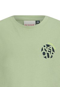 Jasnozielona bawełniana koszulka z okrągłym dekoltem, z granatowym logo z napisem "RETOUR JEANS" z wycinanymi literami.