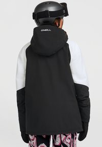 Zwart-witte skijas met capuchon, met een slick ontwerp, lange mouwen en het O'Neill-logo op de rug; ontworpen voor koud weer.