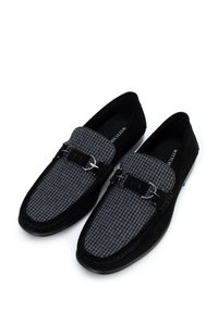 Mocassins en suede noir avec un motif pied-de-poule gris, des éléments décoratifs à l'avant et une semelle lisse.