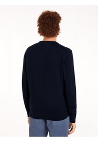 Marineblauer Pullover mit langen Ärmeln, Rundhalsausschnitt und gerippten Bündchen. Hergestellt aus weichem Material, bietet eine glatte Textur und ein klares Design.
