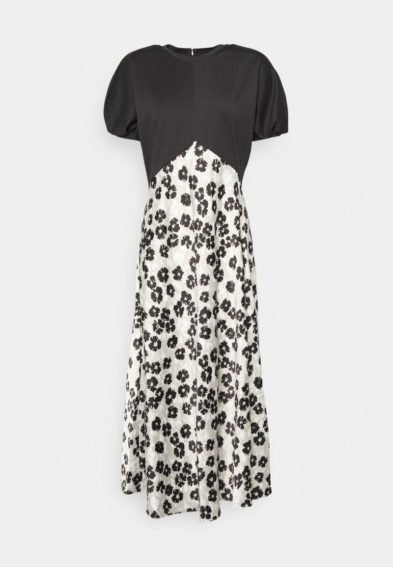Robe noire à manches courtes avec une couture diagonale à la taille, jupe blanche fluide imprimée de fleurs noires, et fermeture zippée au dos.