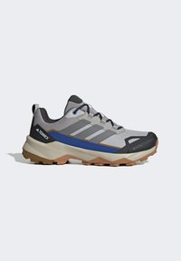 Šedá a černá turistická bota s modrými akcenty, síťovaným vrškem, texturovaným povrchem a robustní podrážkou; obsahuje GORE-TEX pro voděodolnost.