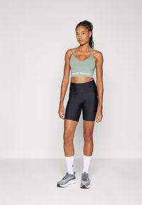 Under Armour VANISH SEAMLESS LOW - Light support sports bra - silica green/white