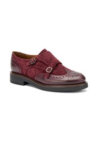 Zapato de ante burdeos con detalles de brogue, doble correa con hebillas plateadas y puntera de cuero brillante. Suela de goma plana.