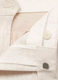 Beige textiel met een gestructureerd ontwerp, zichtbare knoop, ritssluiting en gladde textuur, met contrasterende lichtere en donkerdere tinten.
