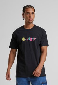 Černé bavlněné tričko s barevným nápisem "homeboy" v hravém písmu. Krátké rukávy a klasický kulatý výstřih.