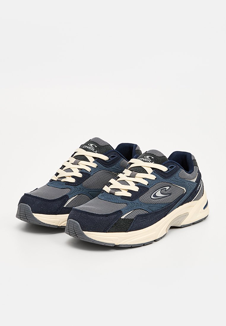 Indigo- und graue Sportsneaker mit Mesh- und Wildlederstrukturen, kontrastierenden elfenbeinfarbenen Schnürsenkeln und Gummisohlen mit einem strukturierten Grip-Muster.