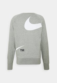 Grå sweatshirt med vita Nike-logotyptryck på baksidan. Ribbstickade muddar och fåll. Tillverkad av mjukt tyg med en avslappnad passform.