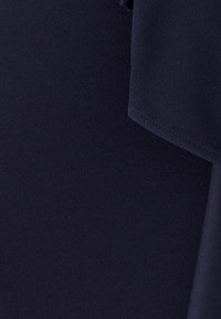 Tumesinine kangas, millel on pehme, sile tekstuur ja kerge läige. Omab voltidega drapeeritud disaini. Puhtalt minimalistlik välimus.