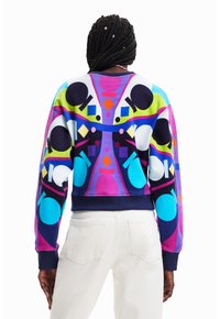 Värikäs, kuvioitu collegepaita, jossa geometrisia muotoja sinisenä, pinkkinä, vihreänä ja mustana, resorireunuksilla hihansuissa ja helmassa.