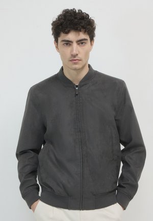 Schwarze Bomberjacke aus strukturiertem Stoff, mit einem Frontreißverschluss, gerippten Bündchen und einem runden Ausschnitt, sowie seitlichen Taschen.