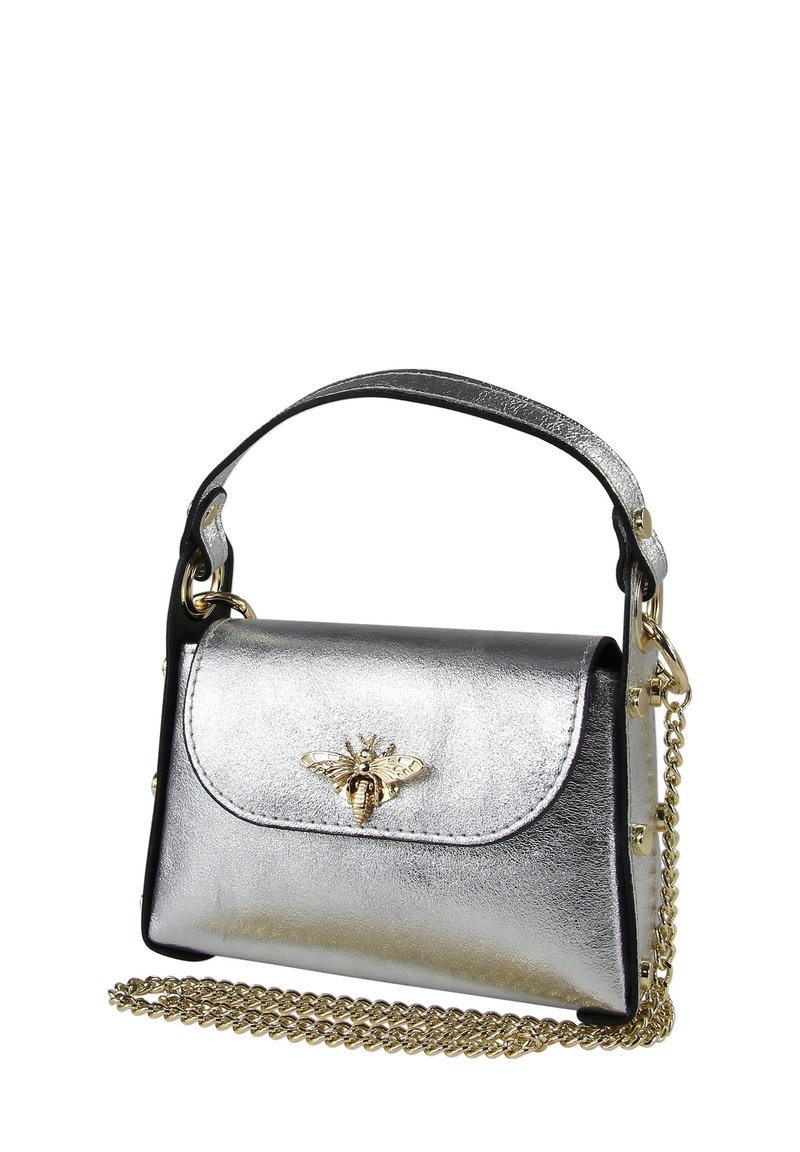 Sac à main argenté métallique avec un accent noir, orné d'un emblème d'abeille doré sur le devant. Comprend une bandoulière chaîne amovible.