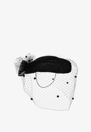 Black vintage-style hat with a netted veil decorated with small pom-poms and a bow at the back.
