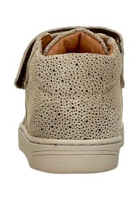 Beige geperforeerde leren schoen met een gestructureerd oppervlak, gevoerde tan binnenkant en een zachte zool; inclusief een klittenbandsluiting.