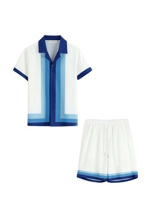 Chemise blanche à manches courtes avec col bleu et rayures bleues en dégradé, associée à un short blanc avec bordure en dégradé bleu assortie.