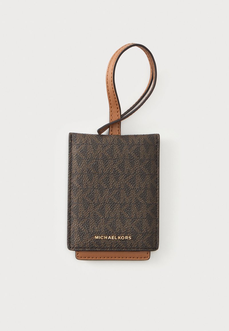 Кафяв държач за карти Michael Kors с текстуриран шарка и кожена гривна на светъл фон.