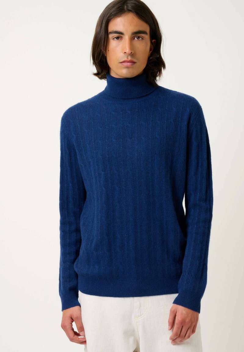 Marineblaues Rollkragensweater mit geripptem Design, das eine figurbetonte Passform und lange Ärmel aufweist. Weicher Stoff mit dezentem Zopfmuster.
