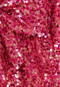 Tessuto fucsia ricoperto di paillettes circolari che riflettono sfumature di rosa e oro, creando una superficie texturizzata e scintillante.