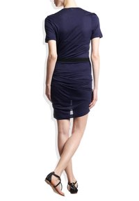 Tmavě modré těsné šaty s krátkými rukávy, řasením a černým pasem. Nosené s černými plochými sandály.