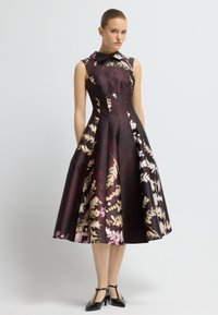 Blumenmusterkleid mit tailliertem Oberteil und ausgestelltem Rock. Aus Seide gefertigt, mit einem dunklen burgunderfarbenen Grundton und hellen Blumenakzenten.