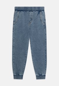 Lyseblå denim joggebukser med elastisk midjebånd, to sidelommer og ribbestrikkede mansjetter. Har subtile sømdetaljer.