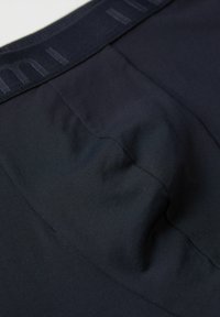 Mörk marinblå sömlösa boxerkalsonger med en åtsittande design, mjuk textur och elastisk midja med en subtil logotyp. Slät yta, utan mönster.