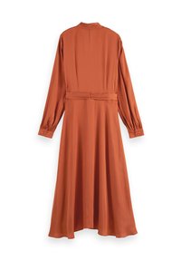 Pitkähihainen, ruosteenoranssi mekko korkealla kauluksella, vyötäröllä vyö ja napitettu hihansuu. Valmistettu sileästä ja pehmeästä kankaasta.