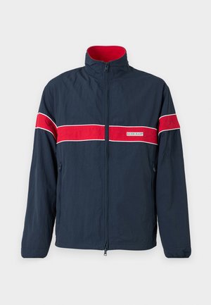 Navy blue zip-up jacket featuring red and white horizontal stripes, a stand collar, and side pockets. Made from lightweight material.