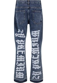 Jeans od traperica u tamnoplavom pranju s bijelim grafičkim tekstom otisnutim na nogavicama. Imaju dva stražnja džepa i dizajn širokih nogavica.