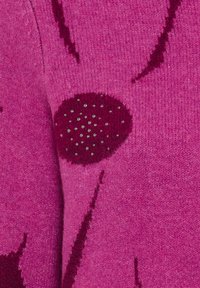 Fuchsia Pullover mit einem strukturierten Blumendesign. Merkmale ein rundes bordeauxrot Detail mit funkelnden Akzenten. Weicher, gestrickter Stoff mit sichtbaren Nähten.