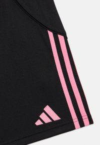 Black athletic shorts featuring three vertical pink stripes along the side and a pink Adidas logo on the hem. Smooth fabric texture.