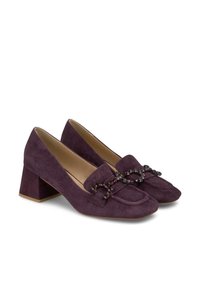 Scarpe con tacco a blocco in suede viola, con punta arrotondata e una cintura decorativa con perline sulla parte superiore. Texture liscia e design a colore unico.