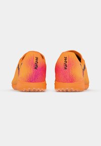 Puma Future Fußballschuhe in Orange-Pink-Verlauf. Schlankes Design mit strukturiertem Obermaterial und Logodetails, ausgestattet mit einer Gummisohle für optimalen Grip.