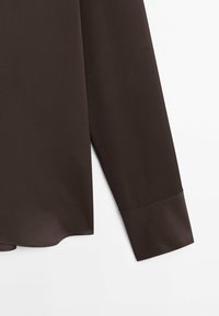 Manche longue de chemise marron foncé avec un large poignet, montrée sur un fond blanc.