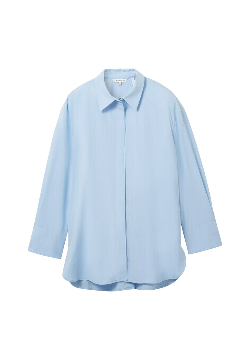Jasnoniebieska koszula zapinana na guziki z wyraźnym kołnierzykiem, długimi rękawami i lekko zaokrąglonym dołem. Wykonana z gładkiego, lekkiego materiału.