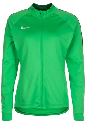 Zielona kurtka Nike z długim rękawem, pełnym zamkiem z przodu, rękawami raglanowymi i małym białym logo Nike Swoosh na górnej lewej piersi.
