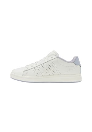 Baskets basses blanches avec des rayures perforées sur les côtés, un talon de couleur gris clair, un col rembourré et des lacets blancs sur une semelle plate.