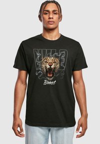 Melnas kokvilnas T-krekls ar lauvas grafiku un vārdiem "WILD" un "Beast" spilgtās, dzīvās krāsās. Īsas piedurknes, apaļš kakls.
