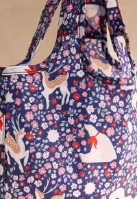 Drobės rankinė su tamsiai mėlynu gėlių raštu, dekoruota elnio ir baltosios meškos motyvais, pagaminta iš tvirto audinio. Lygi tekstūra su tvirtomis rankenomis.