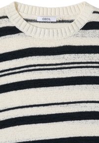 Pull en maille crème et noir à rayures avec col rond côtelé et étiquette de marque « CECIL » à l'intérieur du col.