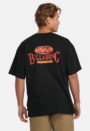 Black cotton t-shirt featuring a large red and orange Billabong logo on the back, with short sleeves and a relaxed fit.