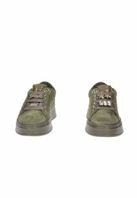 Un paio di sneakers basse in suede verde oliva con suole spesse e charm decorativi sui lacci grigi, vista frontale.